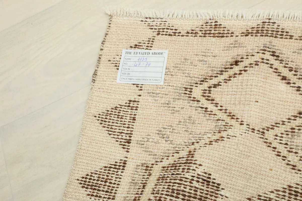 Close-up of the rug's back with a tag, showing the intricate knotting and material details.