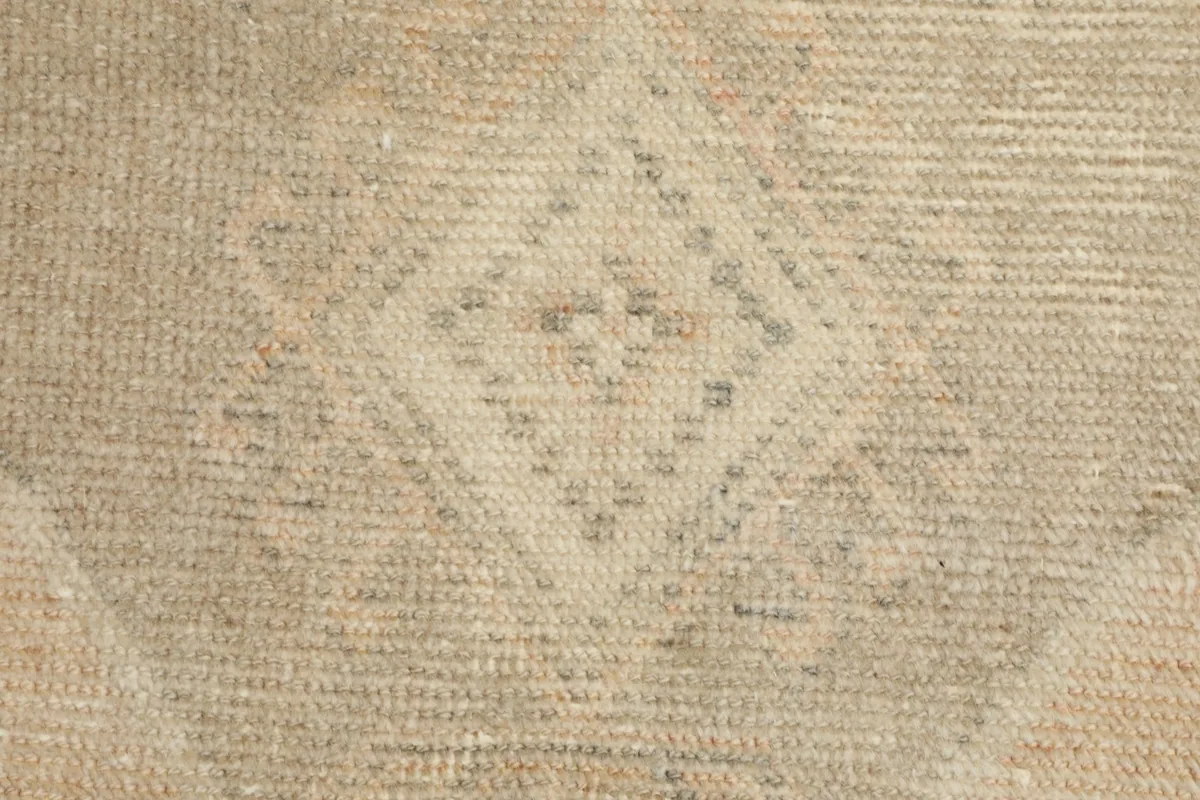 Extreme close-up showing the texture of the wool pile and the intricate knotting of a geometric motif.