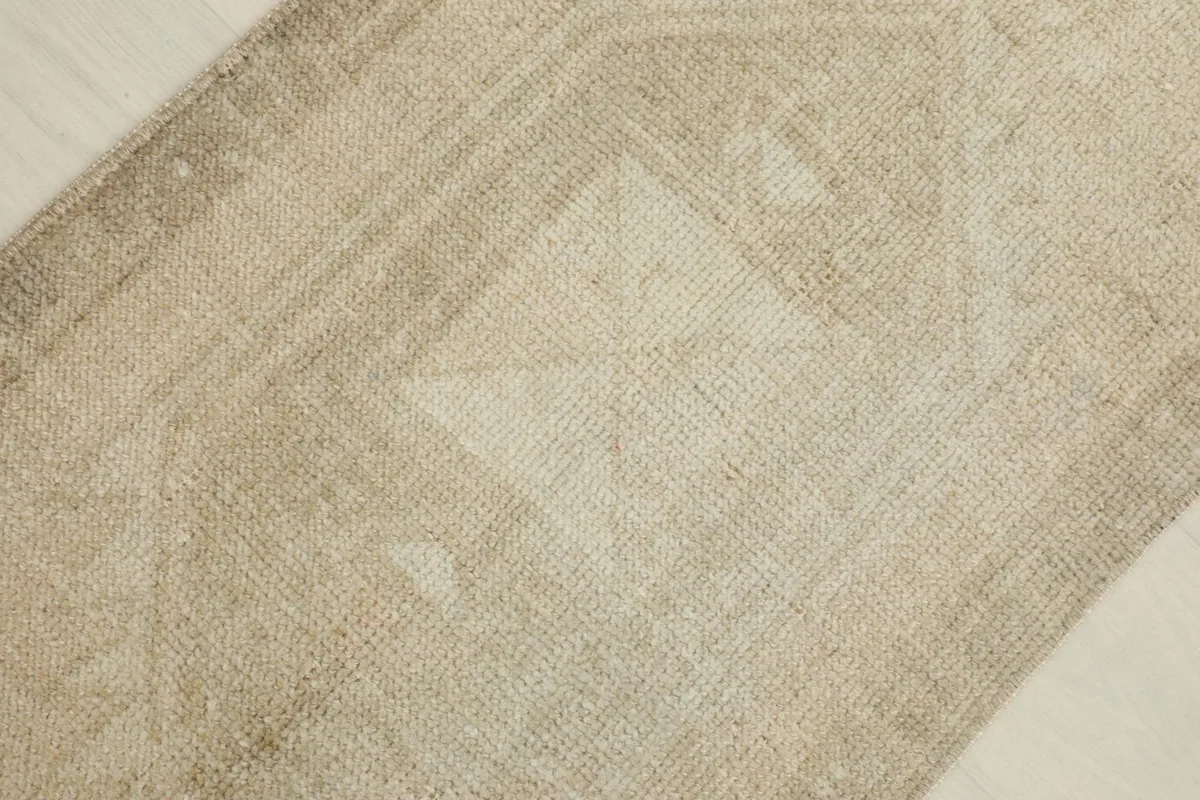 Detail shot of the central geometric motif in the beige field, showing variations in color.