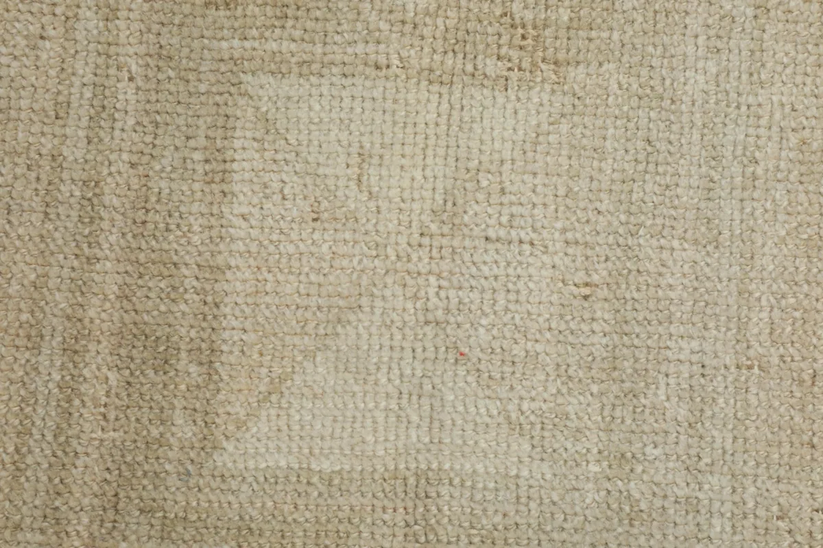 Close-up of the hand-knotted wool pile, revealing the weaving and slight color shifts within the pattern.