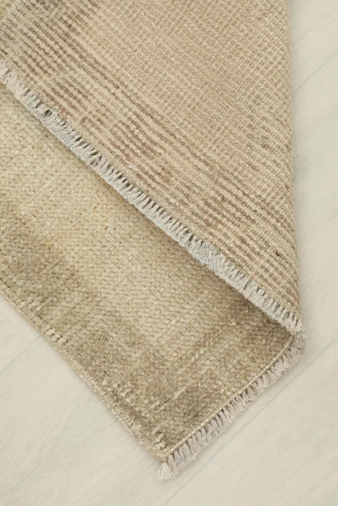 View of the rug folded to show the thickness of the hand-knotted wool pile and cotton foundation.