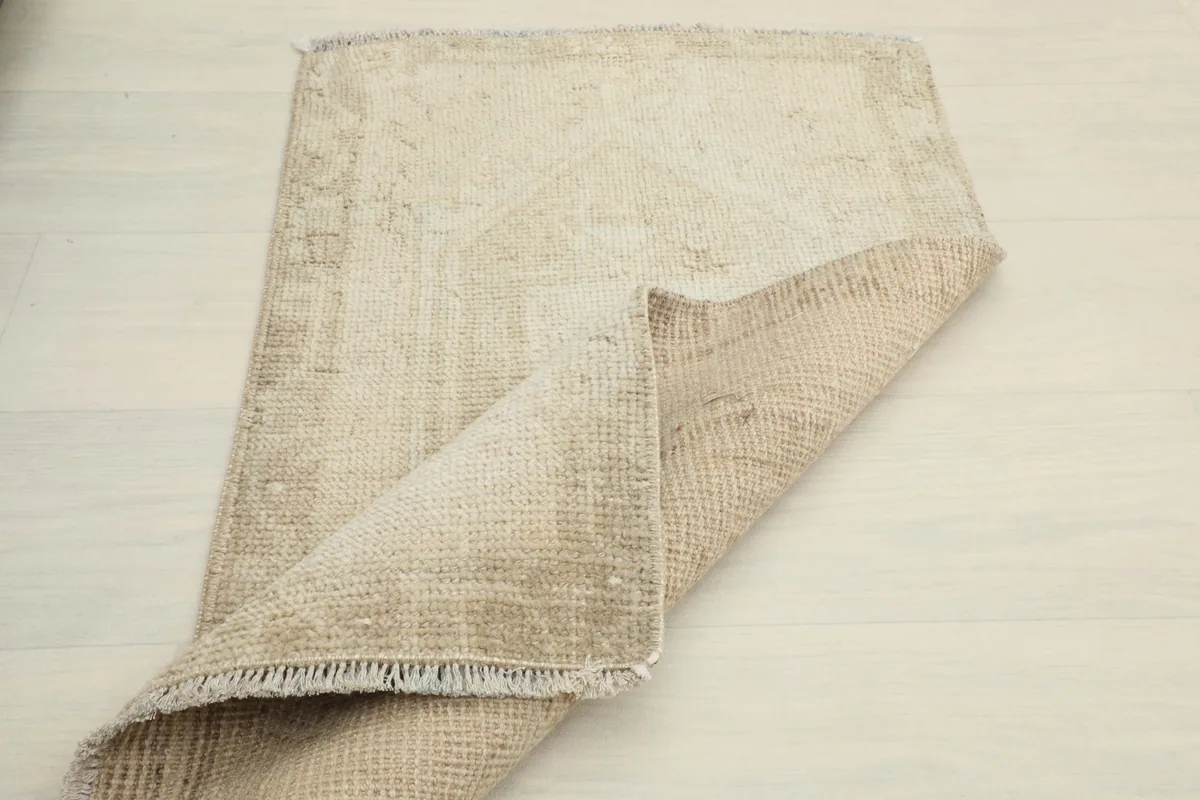 The rug partially folded, illustrating its flexibility and the back of the textile.