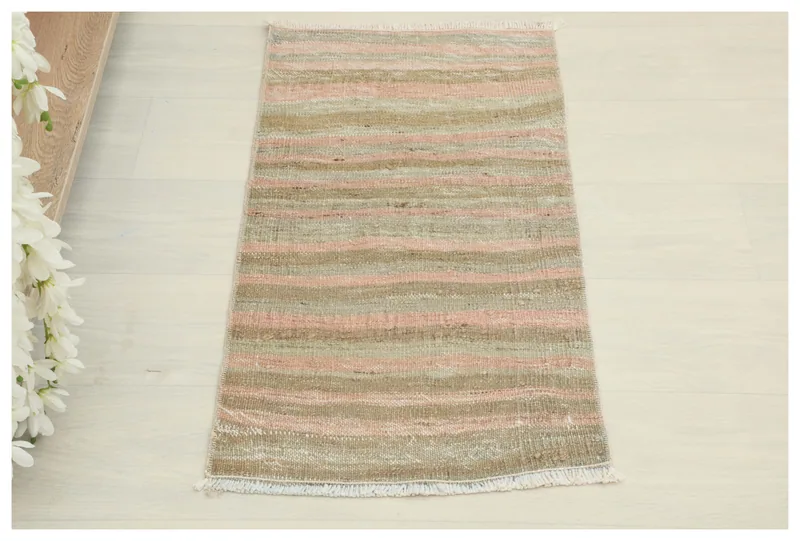 Full overhead view of the 1'4" x 2'7" vintage striped rug with pink, beige, and green colors.