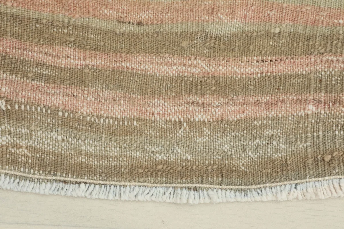 Close-up of one end of the rug, highlighting the texture of the low pile and fringe details.