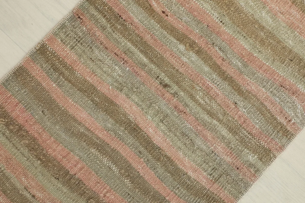 Overhead shot focusing on the striped pattern, showing variations in pink, beige, and green hues.