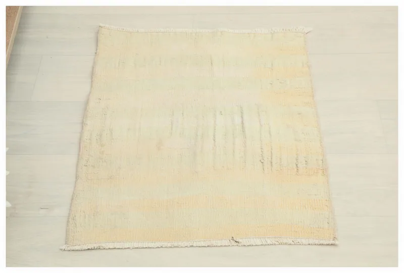 Full top view of the 1'8" x 2'2" cream and beige vintage Anatolian rug on a white background.