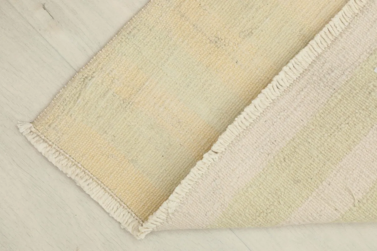 The rug folded to show both the front pile and the sturdy cotton foundation on the back.