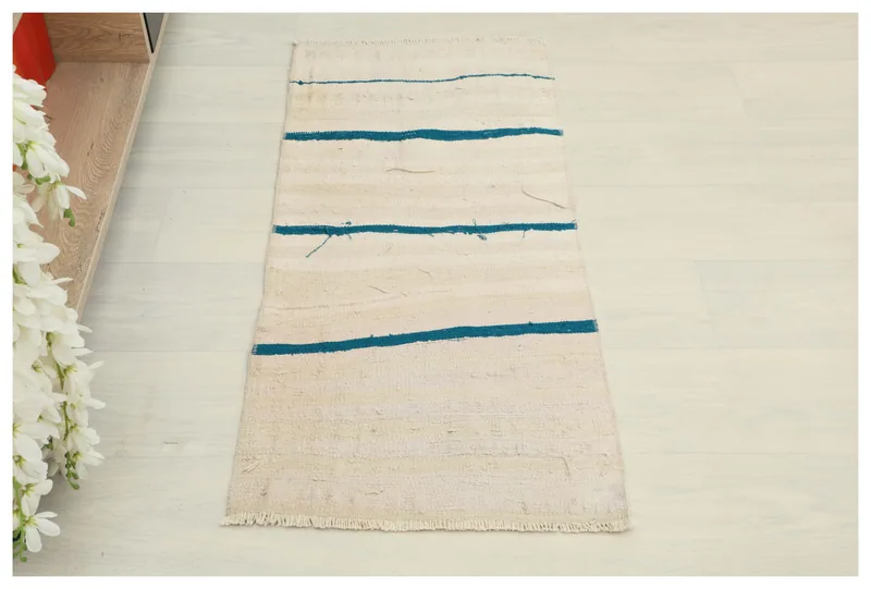 Full top view of the 1'5" x 3'3" vintage Anatolian doormat with ivory and blue stripes.