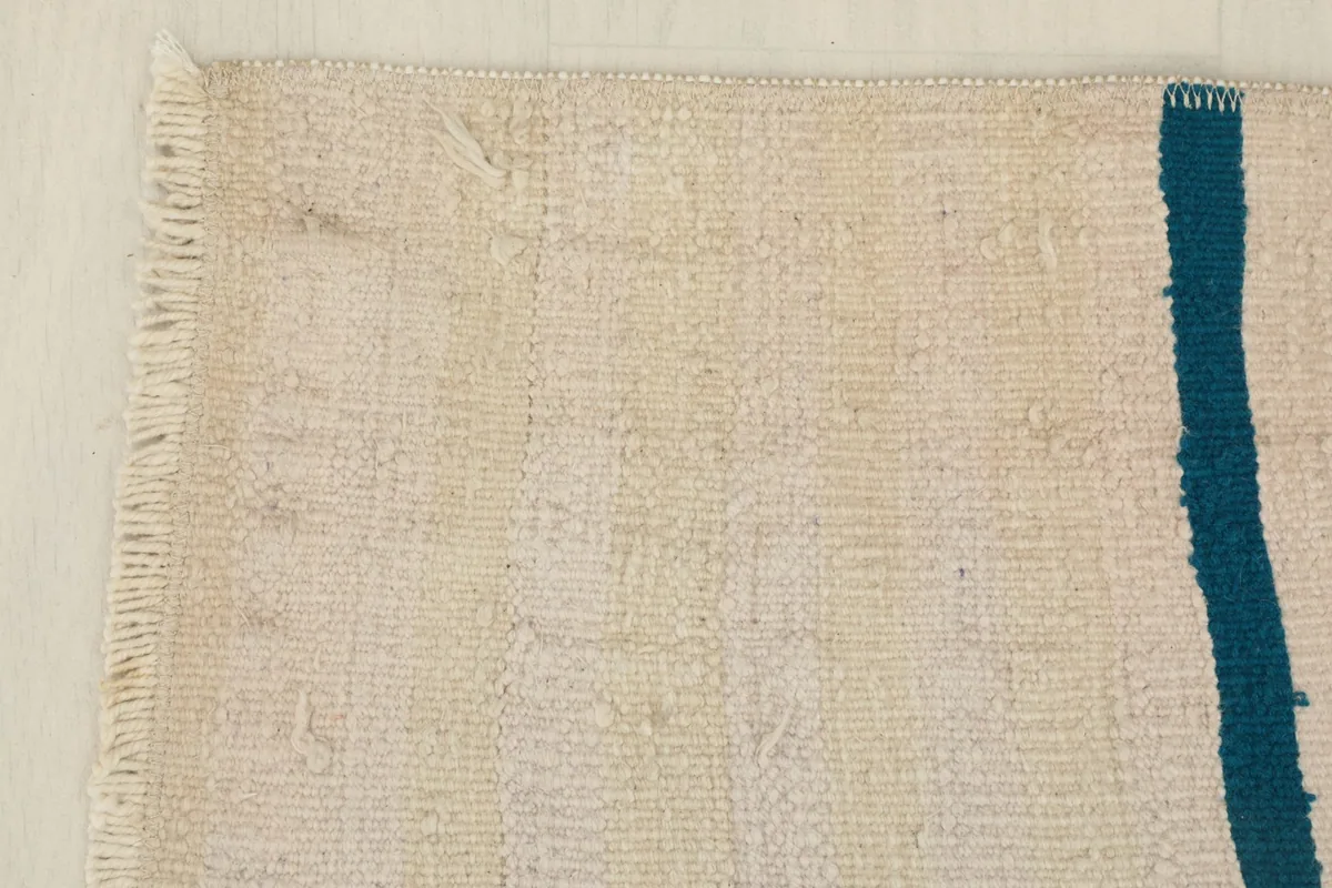 Corner view showing the short, natural fringe and the woven texture of the rug's edge.