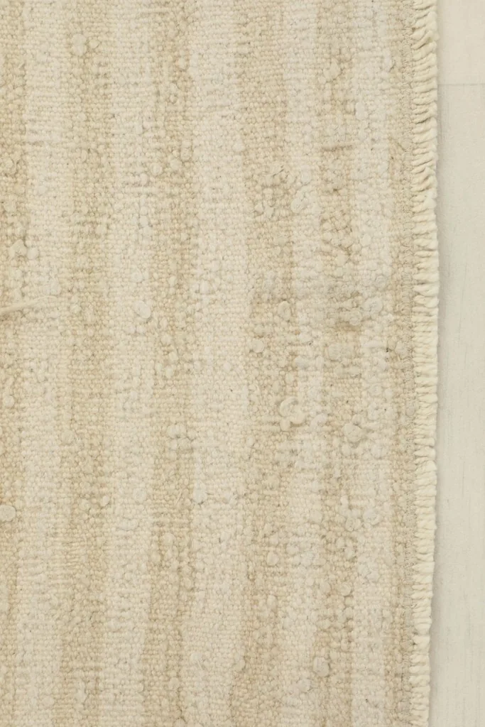 Close-up detail of the hand-knotted wool pile, highlighting the textured beige and tan stripes.