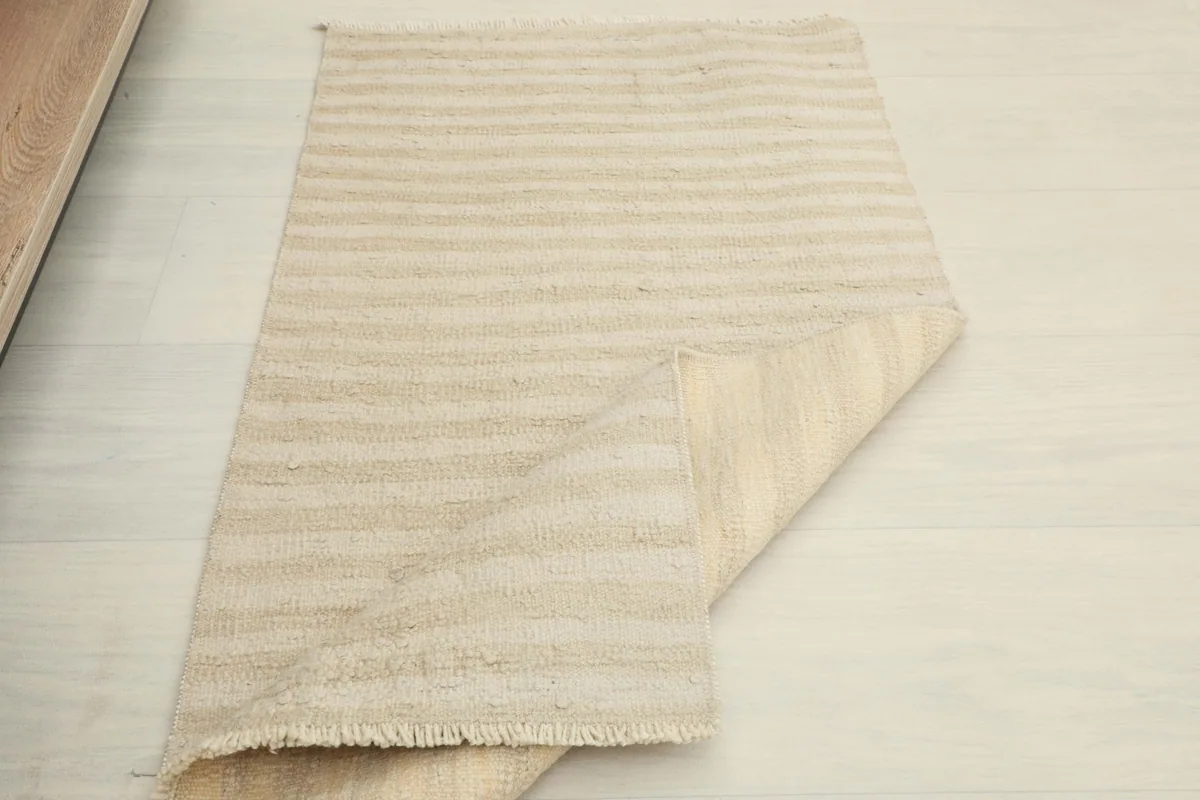 The rug partially folded, showing both the front pile and the woven back.