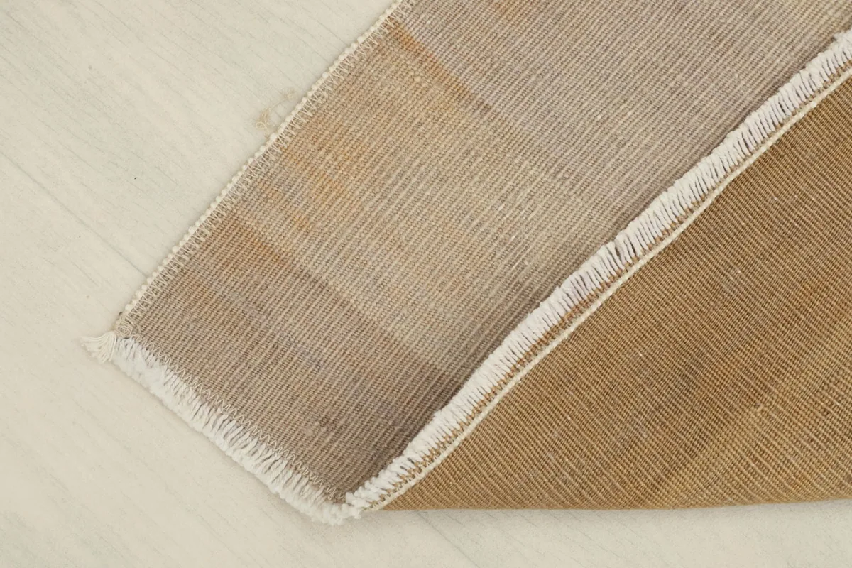View of the back of the hand-knotted rug, revealing the cotton foundation and construction.