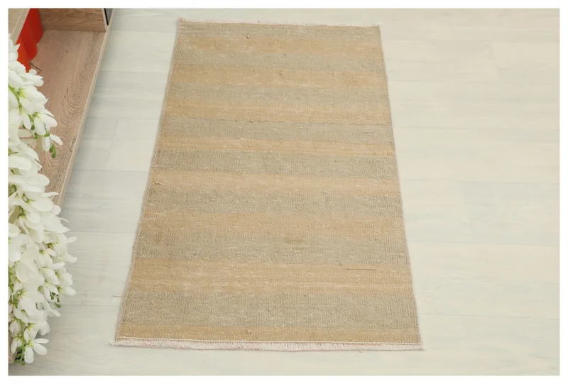 Full overhead view of the beige and gray striped vintage Anatolian rug on a white background.