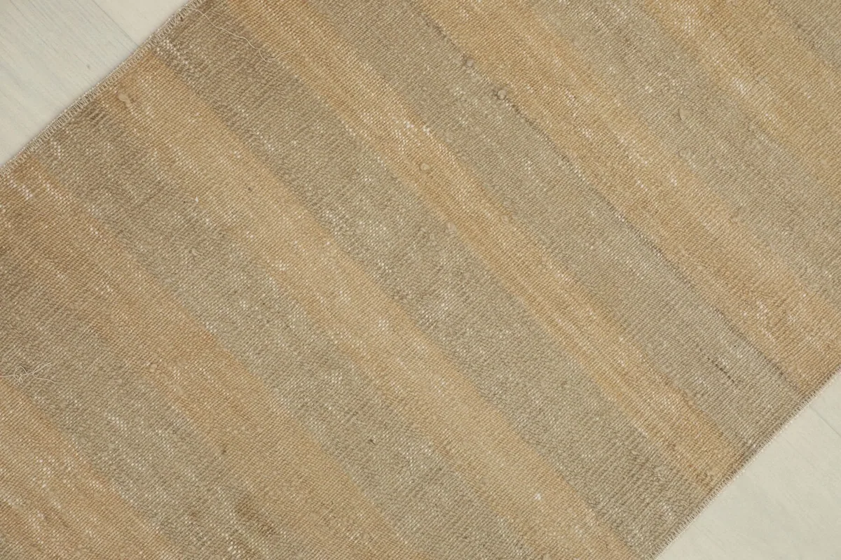 Close-up detail of the hand-knotted wool pile showing the subtle beige and gray stripes.