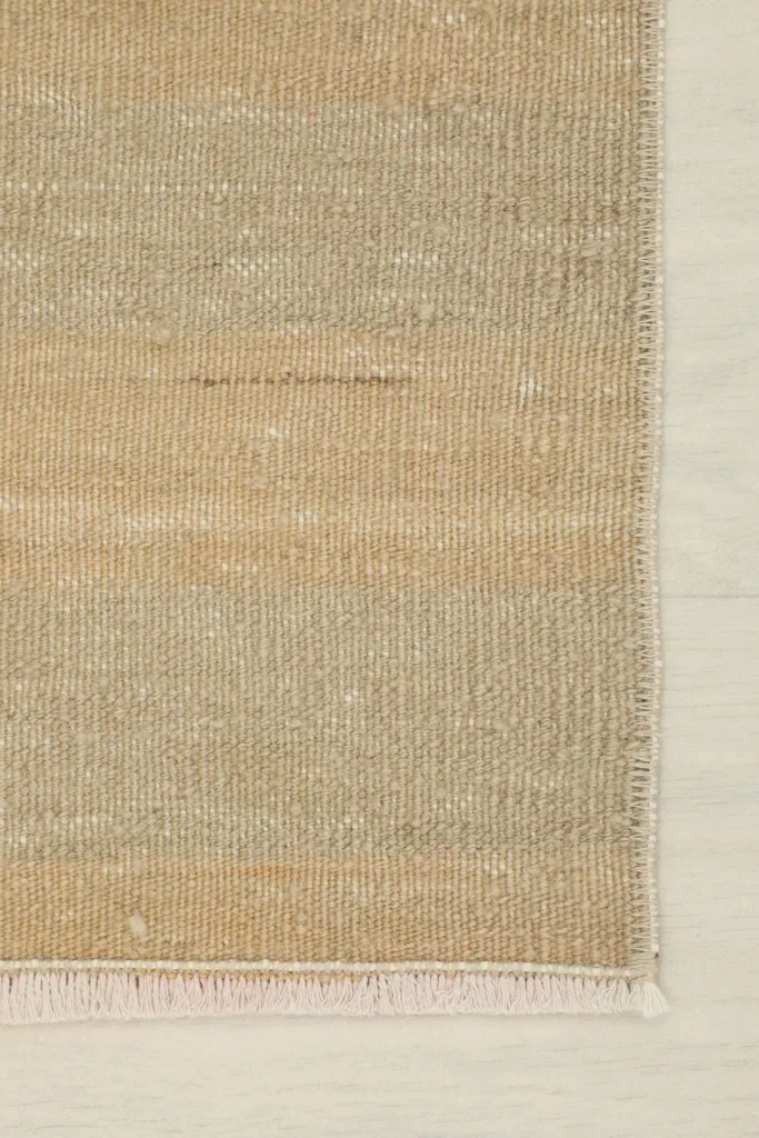 Detail of the rug's edge, showing the neatly finished side and the short fringe.