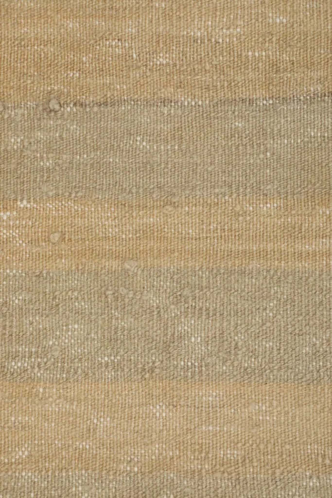 Tight close-up of the low pile texture and color variations in the beige and gray wool.