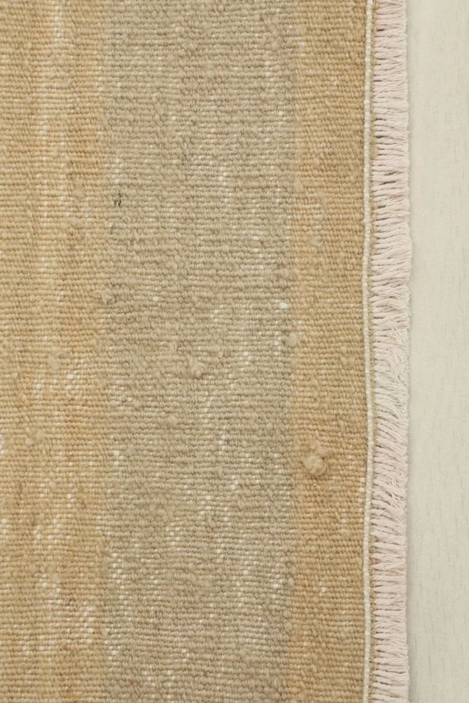 Detail of the short, natural fringe and the tight knotting along the rug's end.