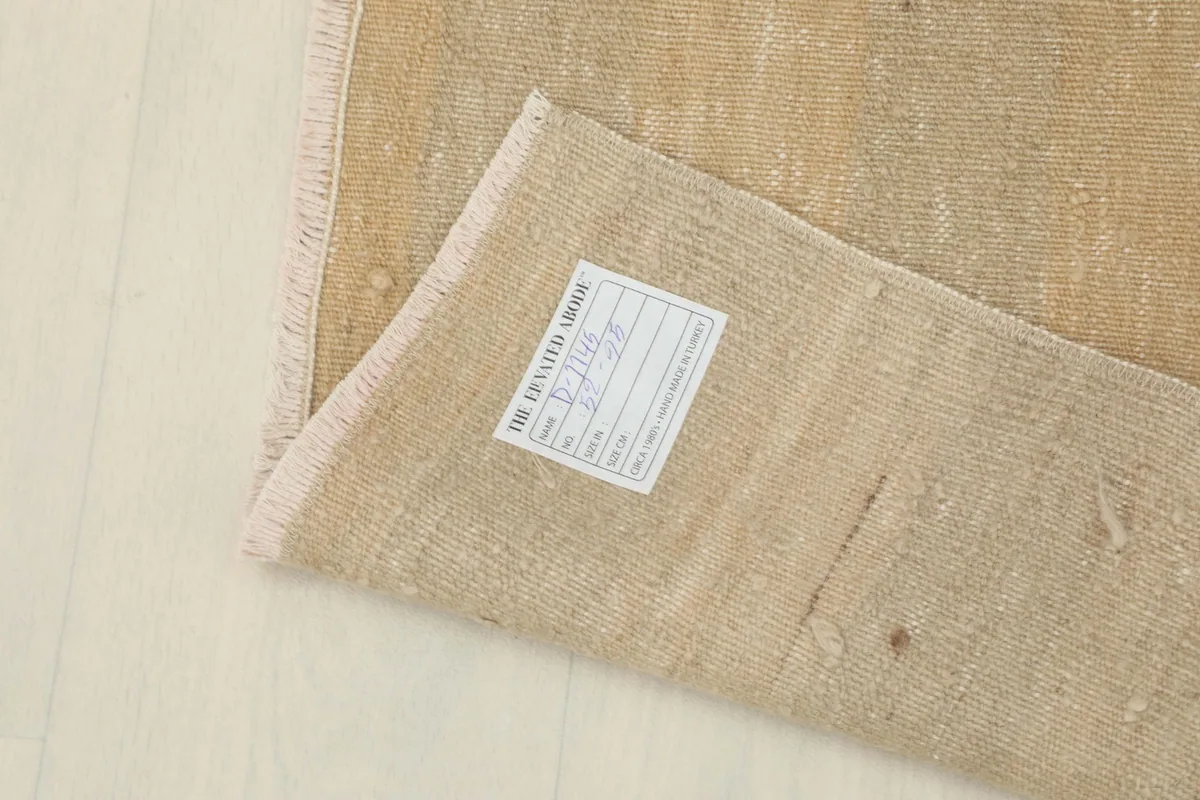 View of the rug's reverse side with a label attached, showing the back of the hand-knotted construction.
