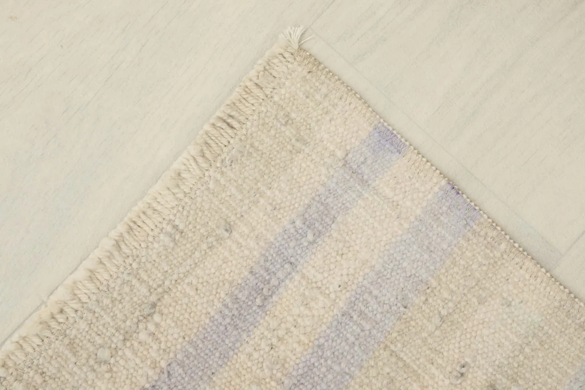 View of the back of the rug, showing the cotton foundation and the tightly woven knots.