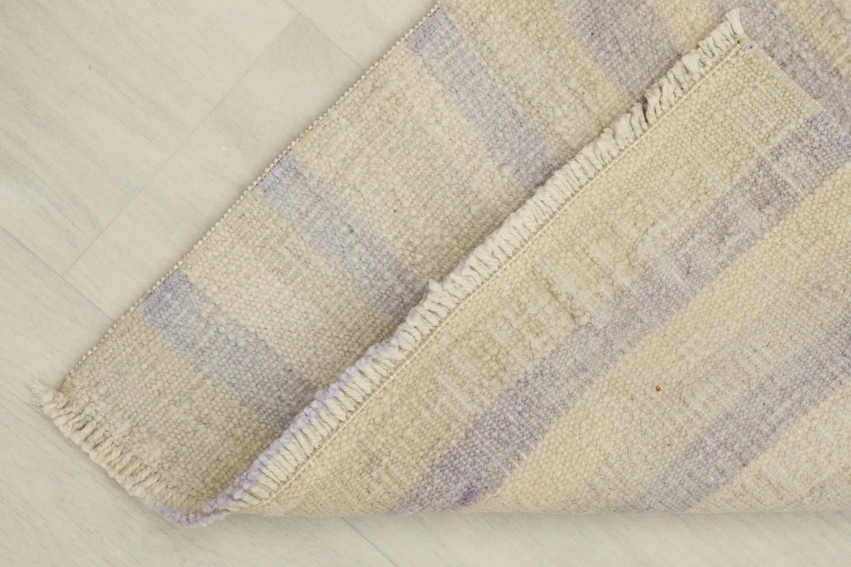 A corner of the rug folded back, showing the thickness and the reverse side.