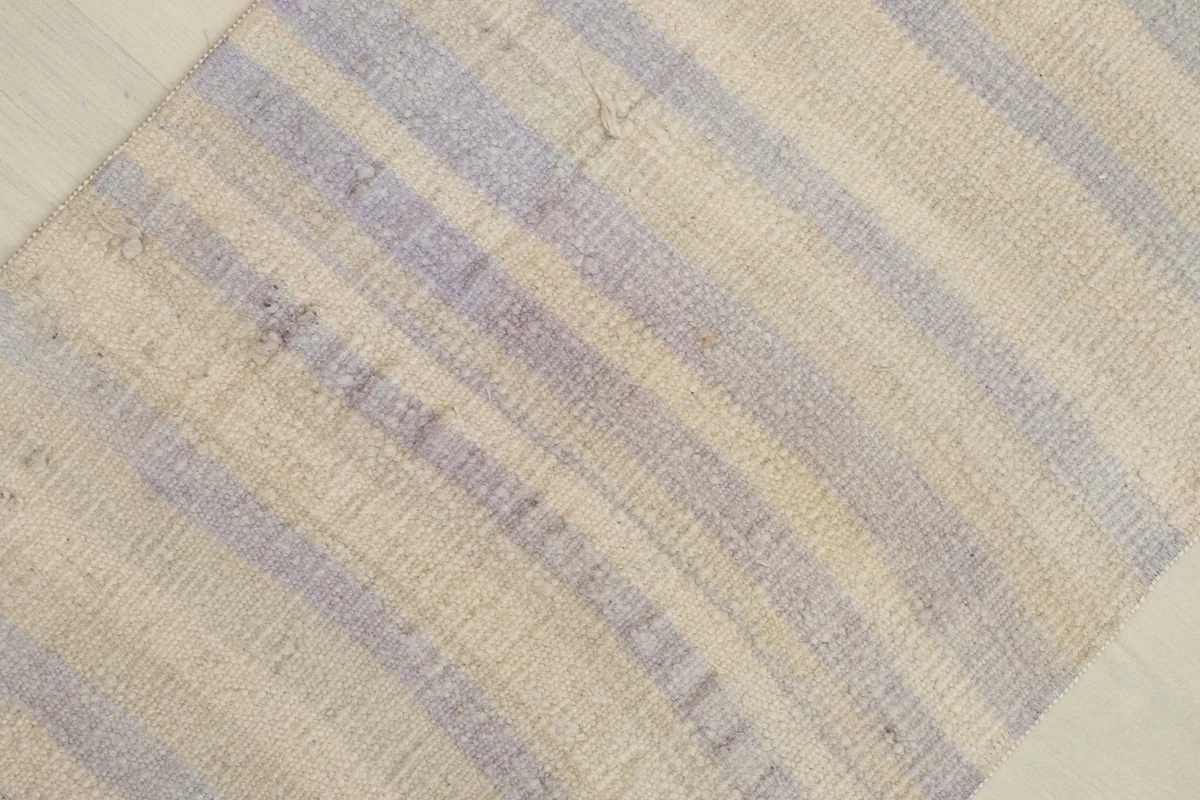 Overhead view focusing on the central part of the rug, emphasizing the alternating ivory and purple stripes.