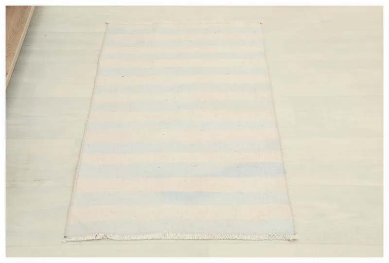 Full overhead view of the 1'9" x 2'9" cream and blue striped vintage doormat.