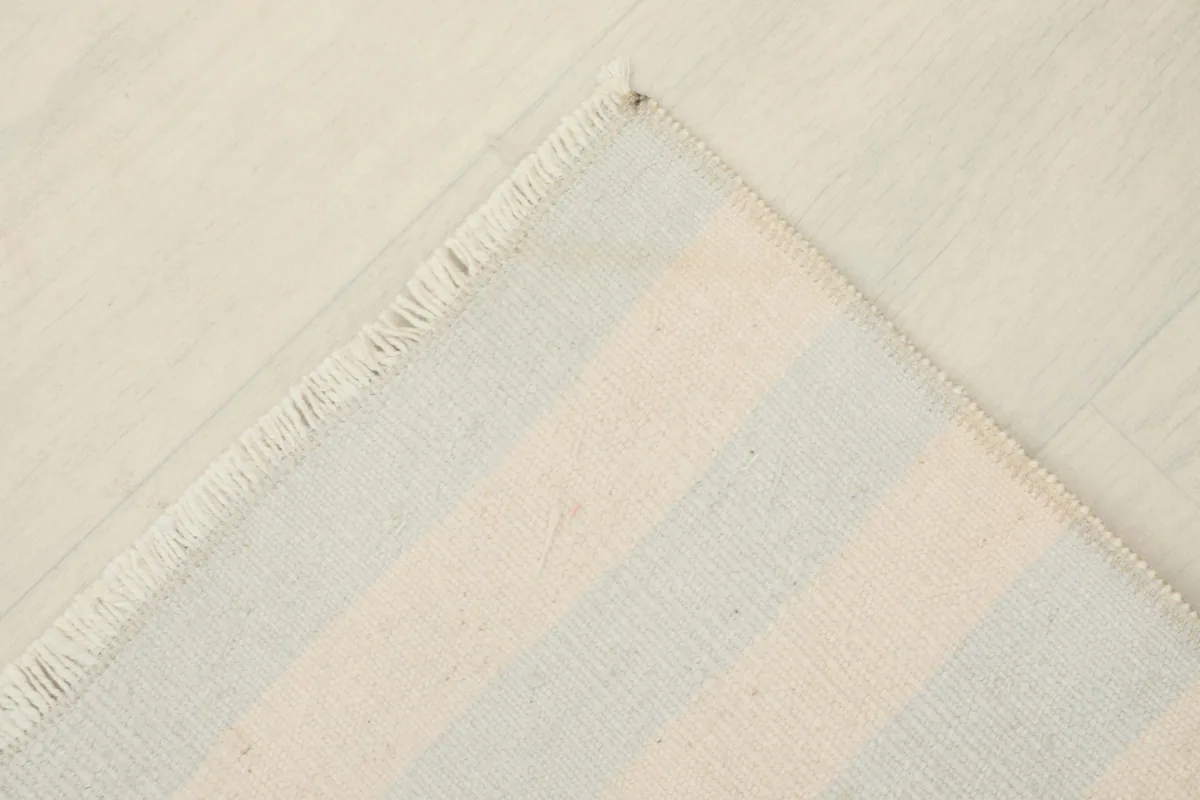 Corner view of the rug's back, revealing the hand-knotted cotton foundation.