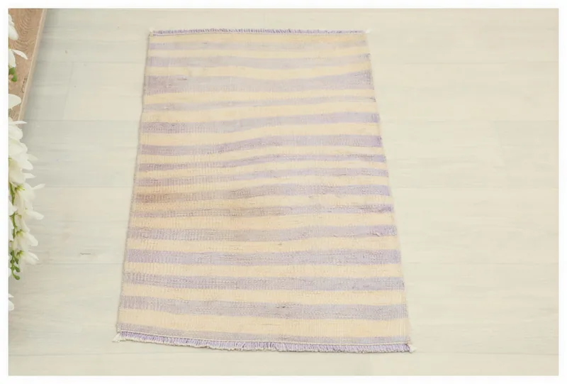 Full top view of the 1'5" x 2'5" purple and ivory striped vintage Anatolian area rug on a white floor.