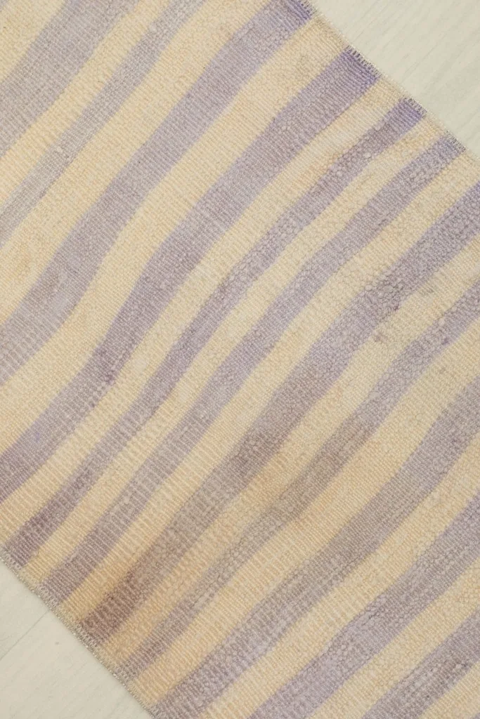 Detailed angled view highlighting the horizontal purple and ivory stripes and the texture of the wool pile.