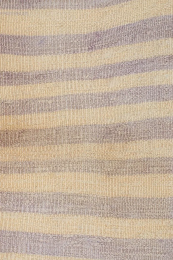 Close-up of the hand-knotted wool pile, showing the distinct purple and ivory stripes and slight variations.