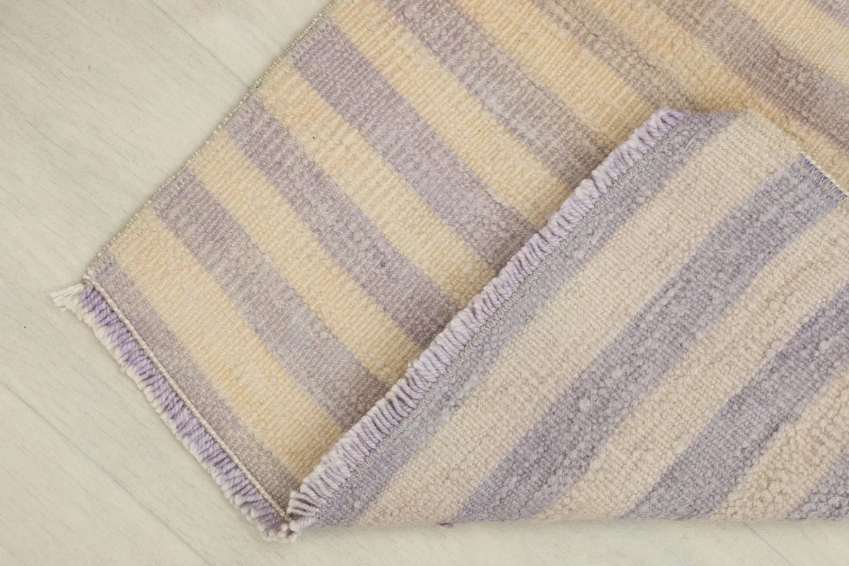 The rug folded to reveal the reverse side, showing the hand-knotted construction and cotton foundation.