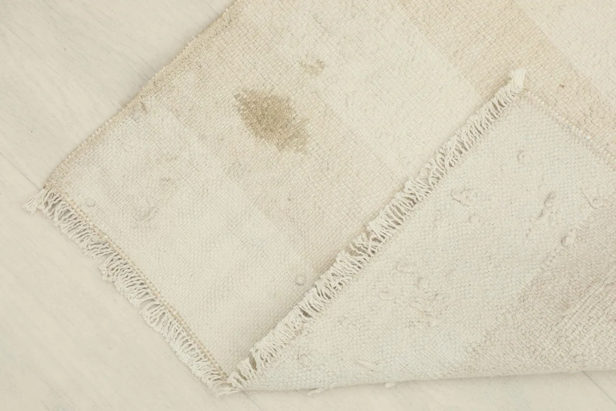Partially folded rug showing the thickness of the wool pile and the hand-knotted reverse.