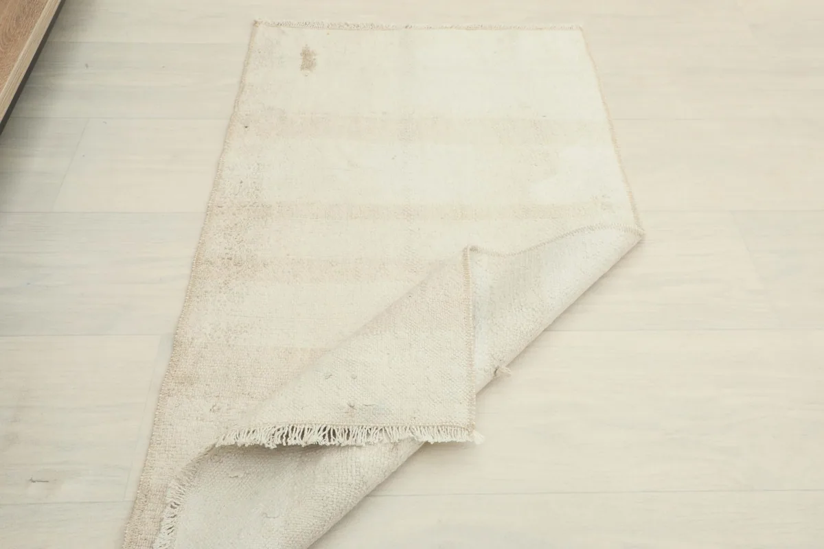 Angled view of the rug folded, displaying its flexibility and the texture of both sides.