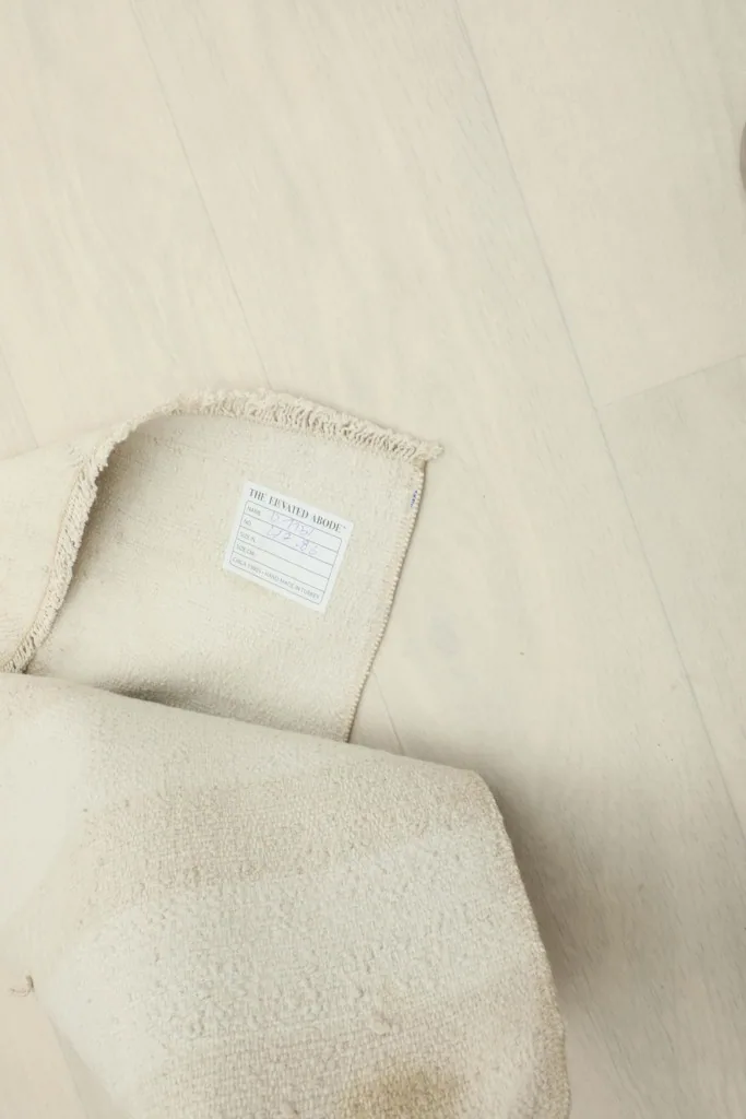Close-up of the care label attached to the back of the vintage hand-knotted wool rug.