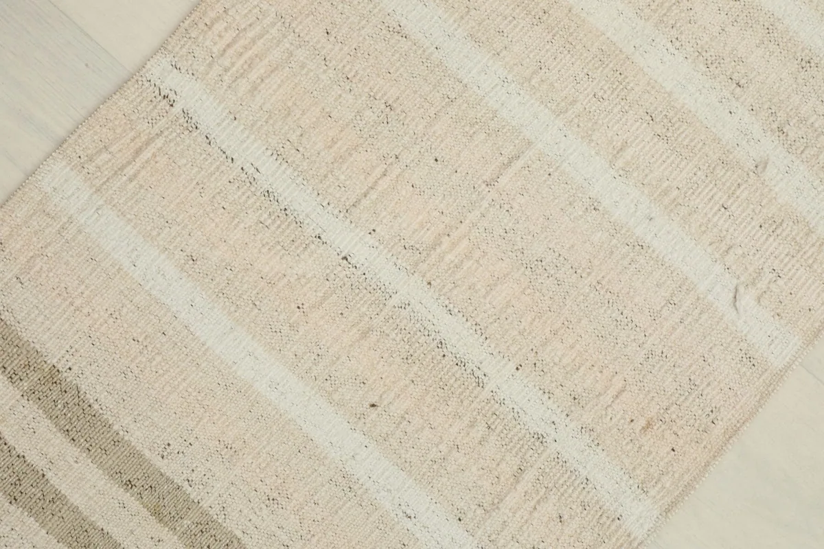 Overhead close-up showing the subtle color variations and striped pattern of the rug