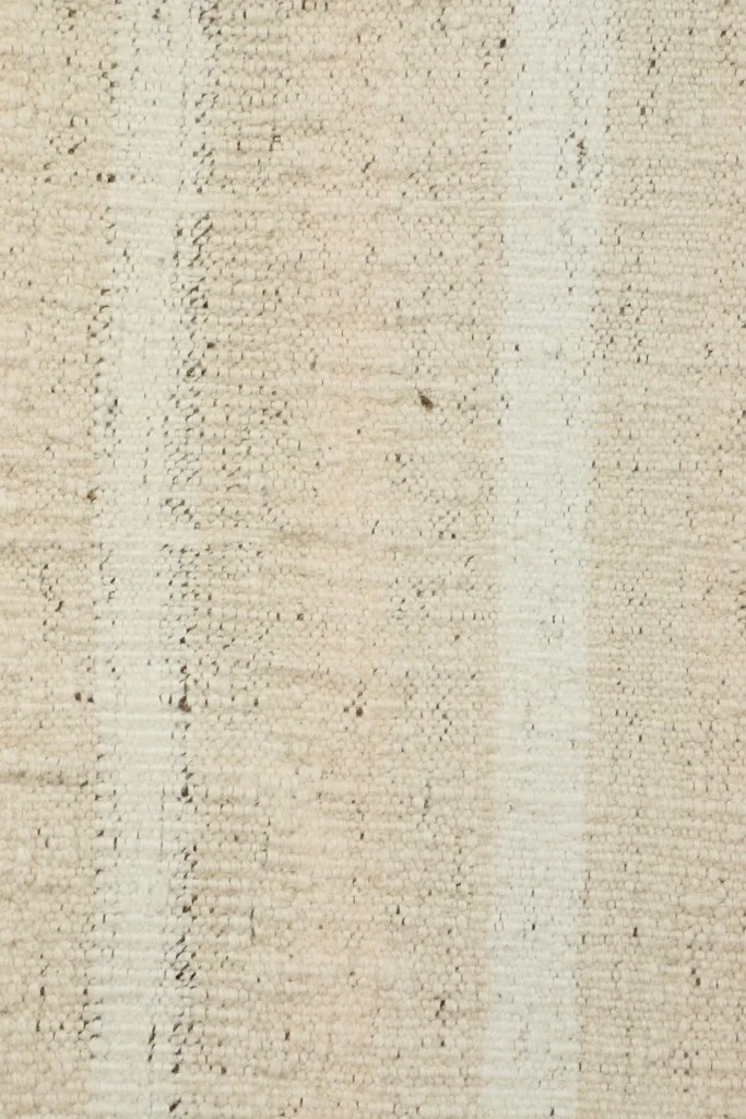 Extreme close-up of the low pile and hand-knotted wool texture of the vintage rug