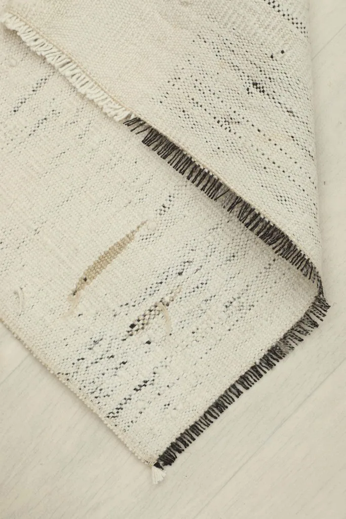 Rug partially folded, displaying the thickness of the material and the character of the edges.