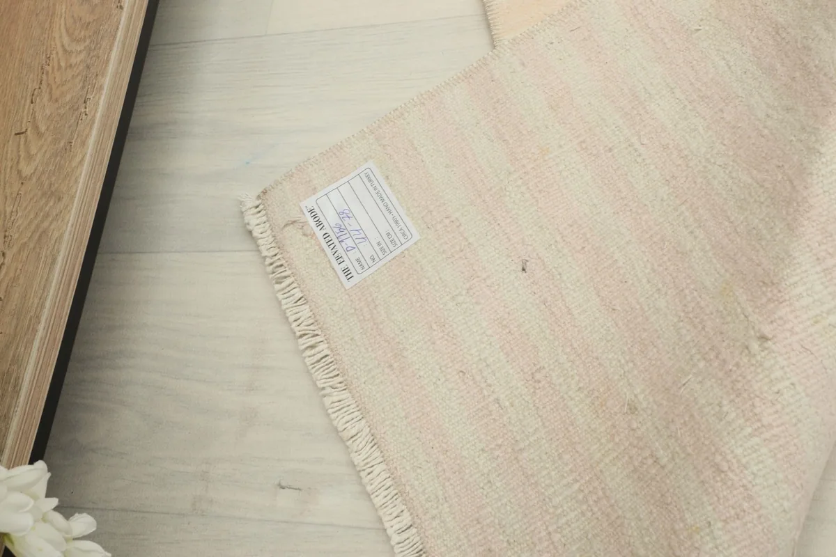 Close-up of the rug's back, showing the tight knotting and the product label attached to the foundation.