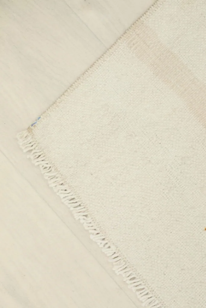 Corner view of the rug, illustrating the clean edges and the natural patina.