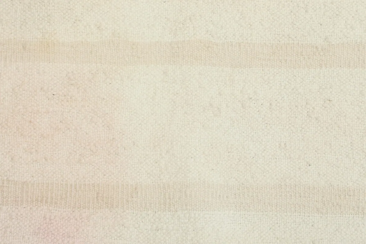 Close-up of the low wool pile texture and the alternating cream and beige stripes.