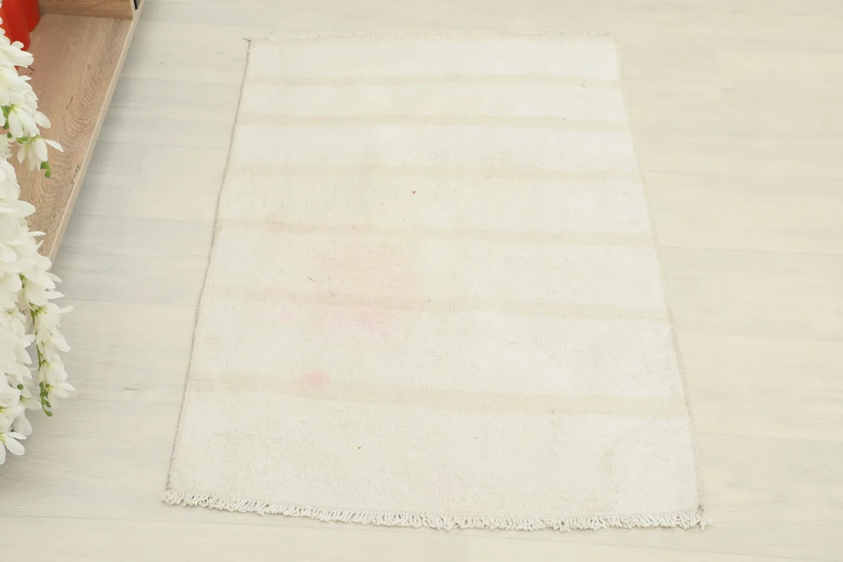 Overhead shot of the small hand-knotted rug, highlighting the striped pattern and overall condition.