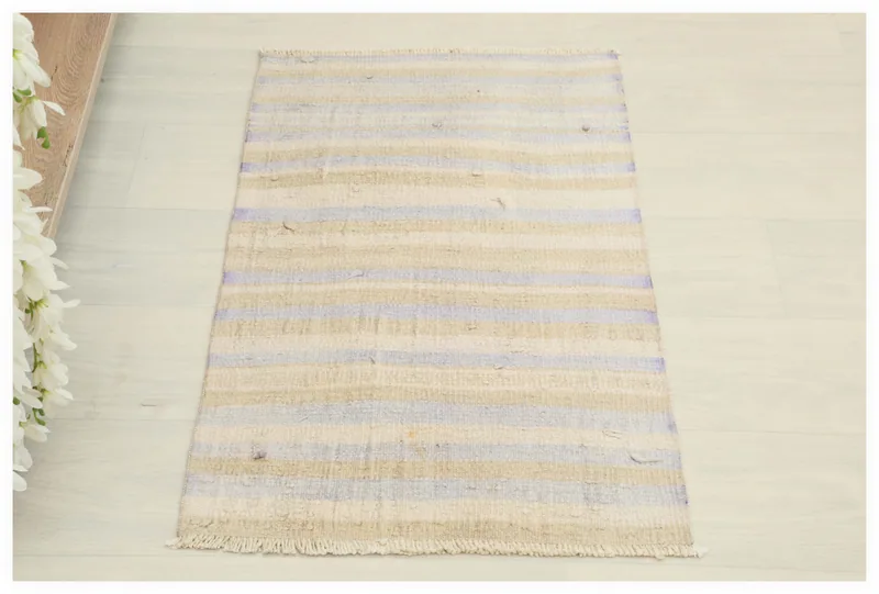 Full top view of the beige and purple striped vintage Anatolian rug on a white background.
