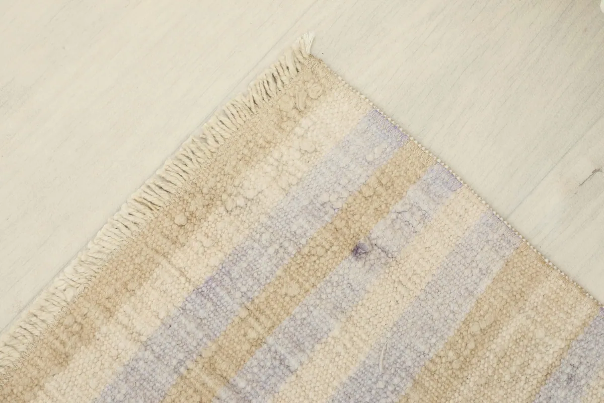 Corner view of the rug, showing the integrity of the weaving and the short, natural fringe.