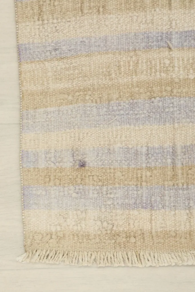 Edge detail of the rug, illustrating the hand-knotted construction and natural fringe.