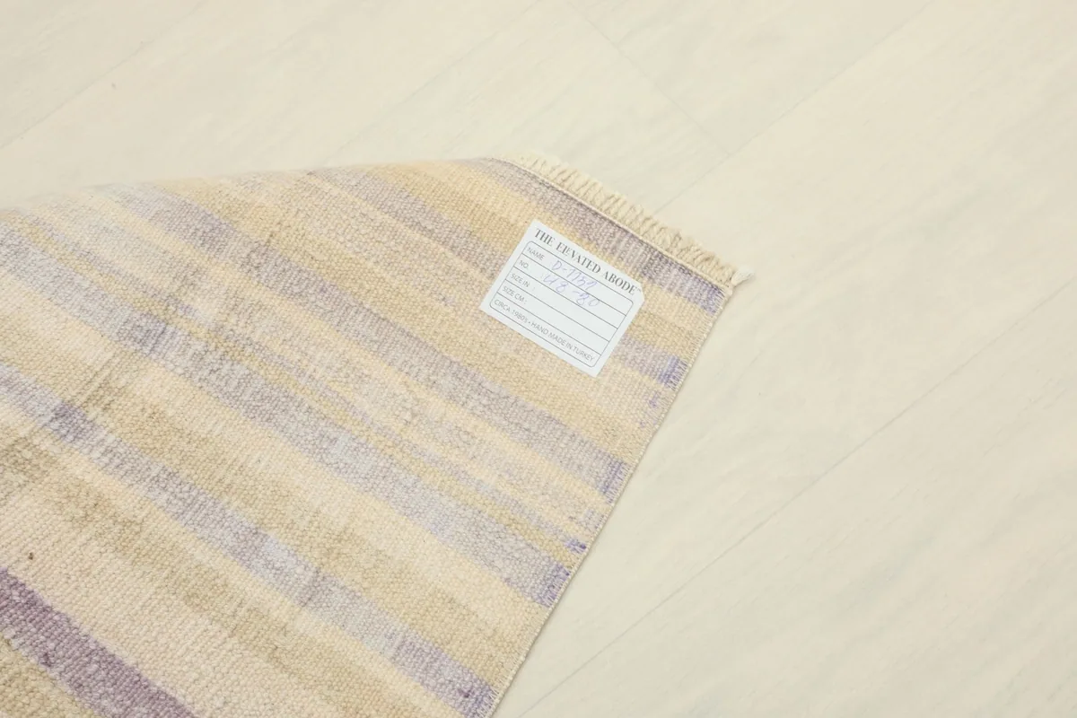 View of the back of the rug, showing the cotton foundation and the tightly hand-knotted construction.
