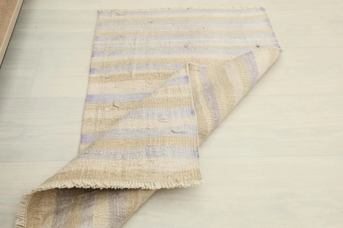 Another view of the rug folded, demonstrating its pliable nature and the texture of the back.