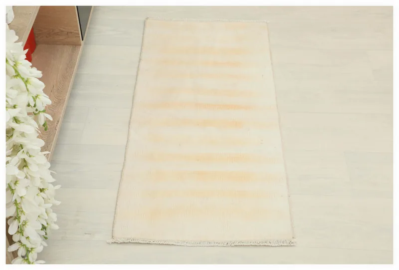 Full top view of the 1'6" x 3'3" cream and tan striped vintage Anatolian doormat on a white background.