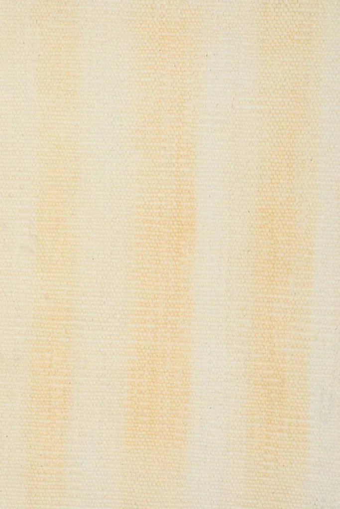 Overhead close-up of the low wool pile, highlighting the subtle texture and color shifts in the stripes.