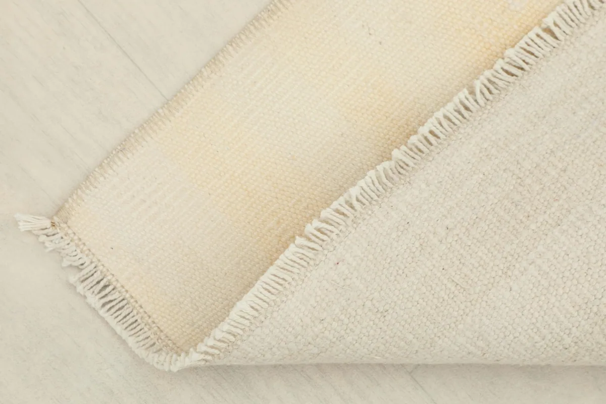 Another view of the reverse side of the rug, showing the consistent hand-knotted weave and fringe.