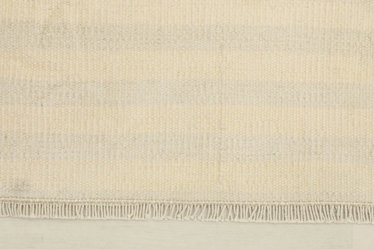 Close-up of the subtle striped pattern and fringe on the vintage wool rug